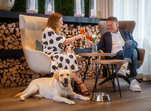 Paar sitzt mit Hund in der Hotellobby des Hotel Dilly