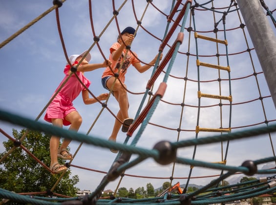 Mädchen am Kletternetz am Spielplatz im Dilly Resort