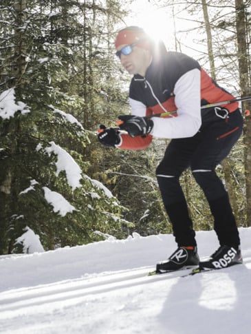 Cross-country skiers on a descent in the forest